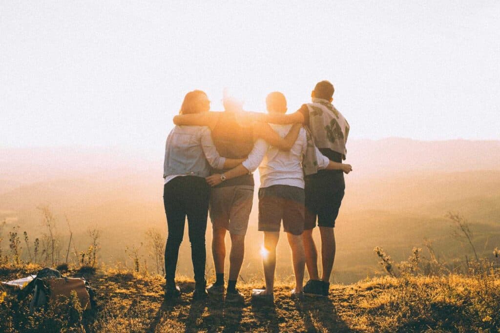Gemeinschaftliche Freundschaft im Sonnenuntergang Gruppe von Freunden beim Sonnenuntergang in der Natur.