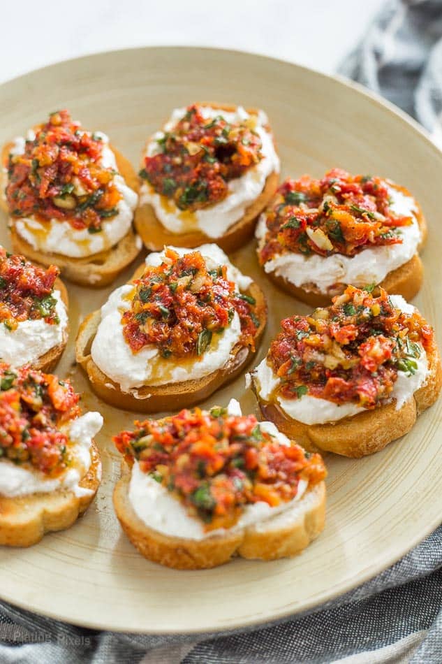 Sun Dried Tomato Ricotta Crostini on a stone colored plate