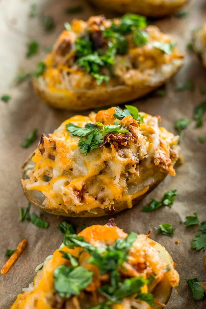 Three Carnitas Loaded Potato Skins on a baking sheet
