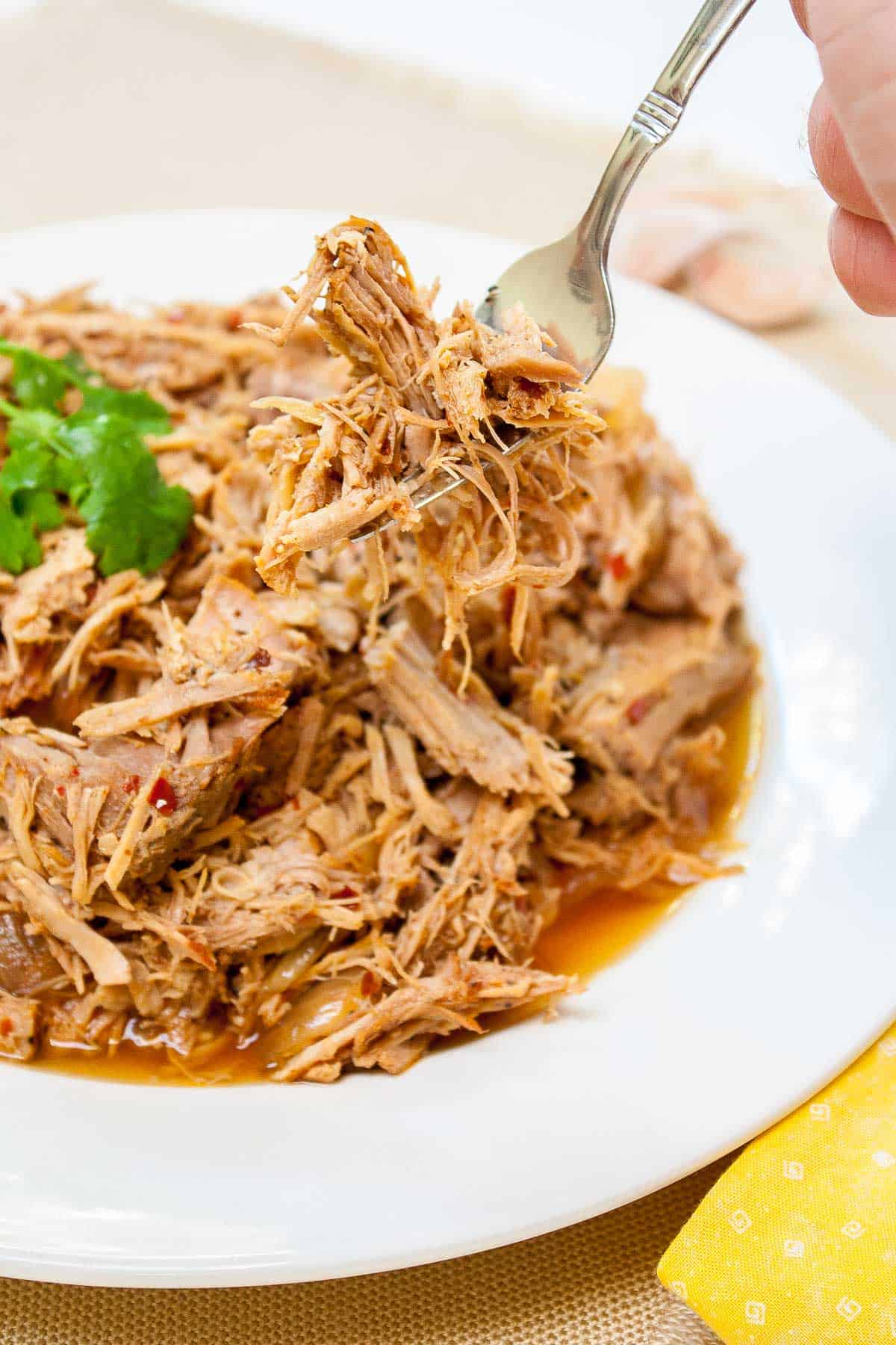 A close up of Carolina Style Slow Cooker Pulled Pork on a fork