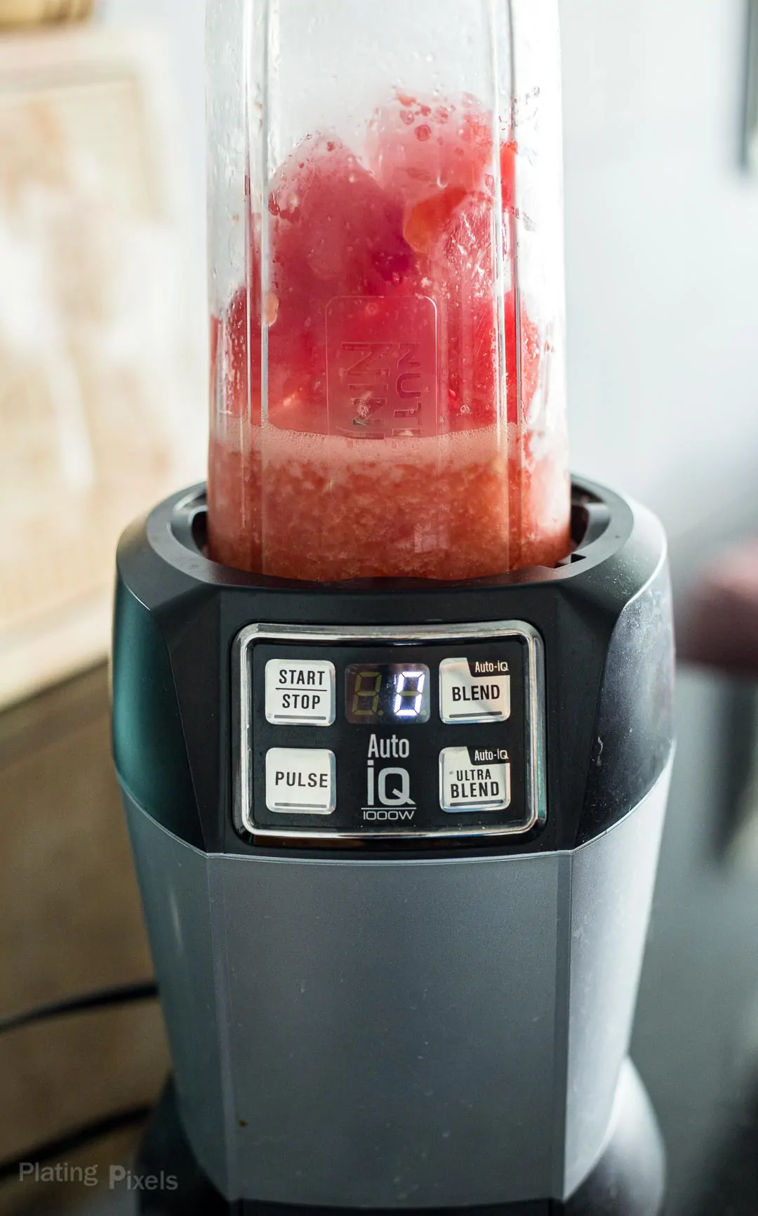 Process shot of blending watermelon margarita in a high-speed blender