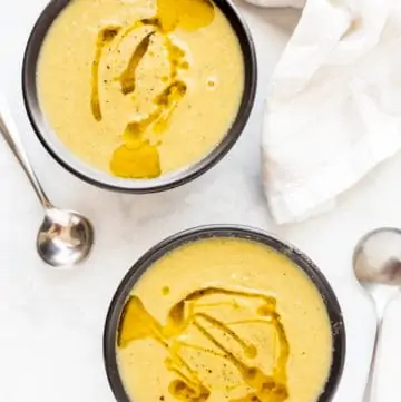 Two bowls of Leek and Cauliflower Soup on a white marbe table