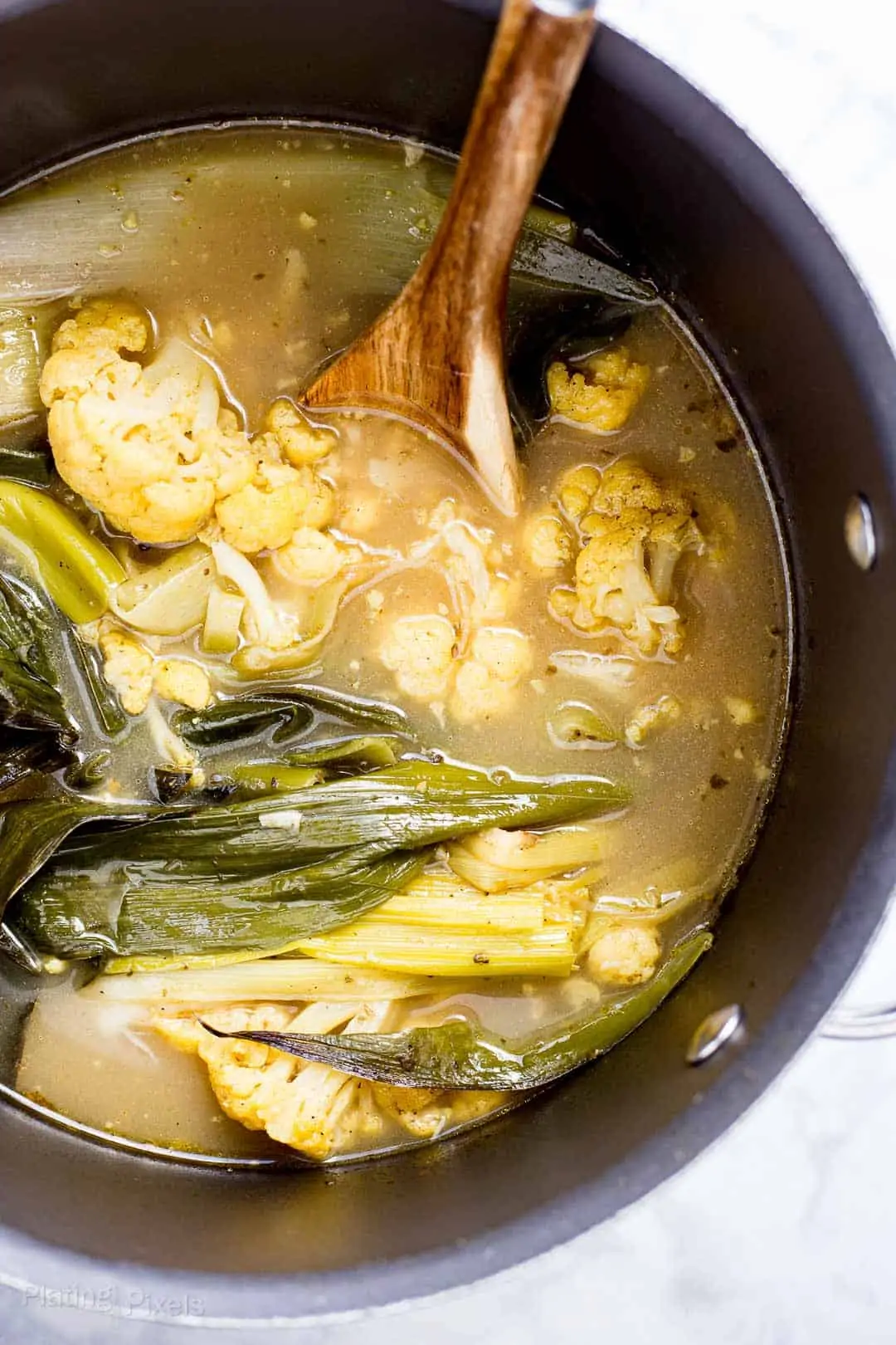 Leek and Cauliflower Soup simming in a pot on the stove