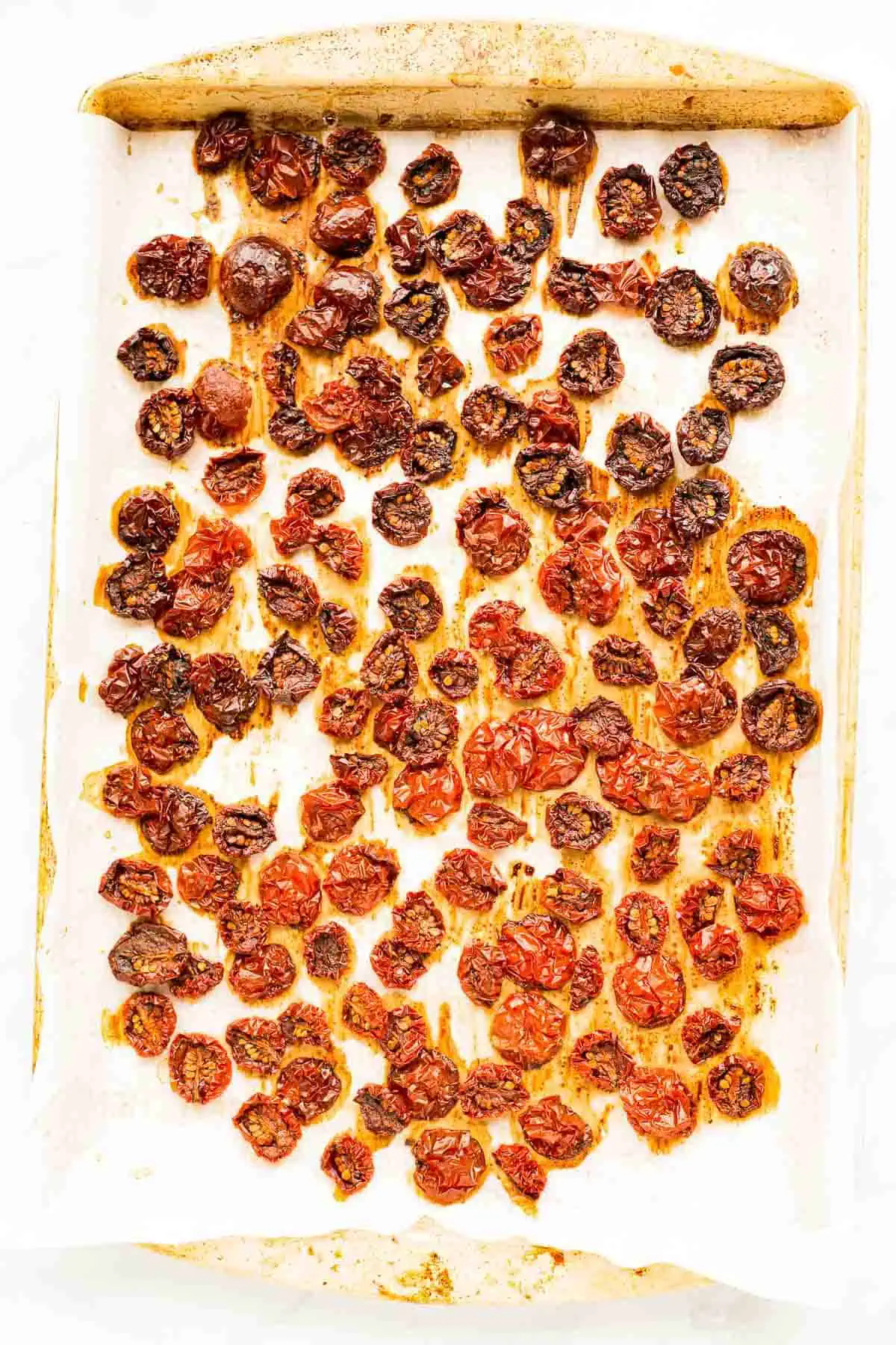 Oven Dried Tomatoes on a baking sheet vertical image