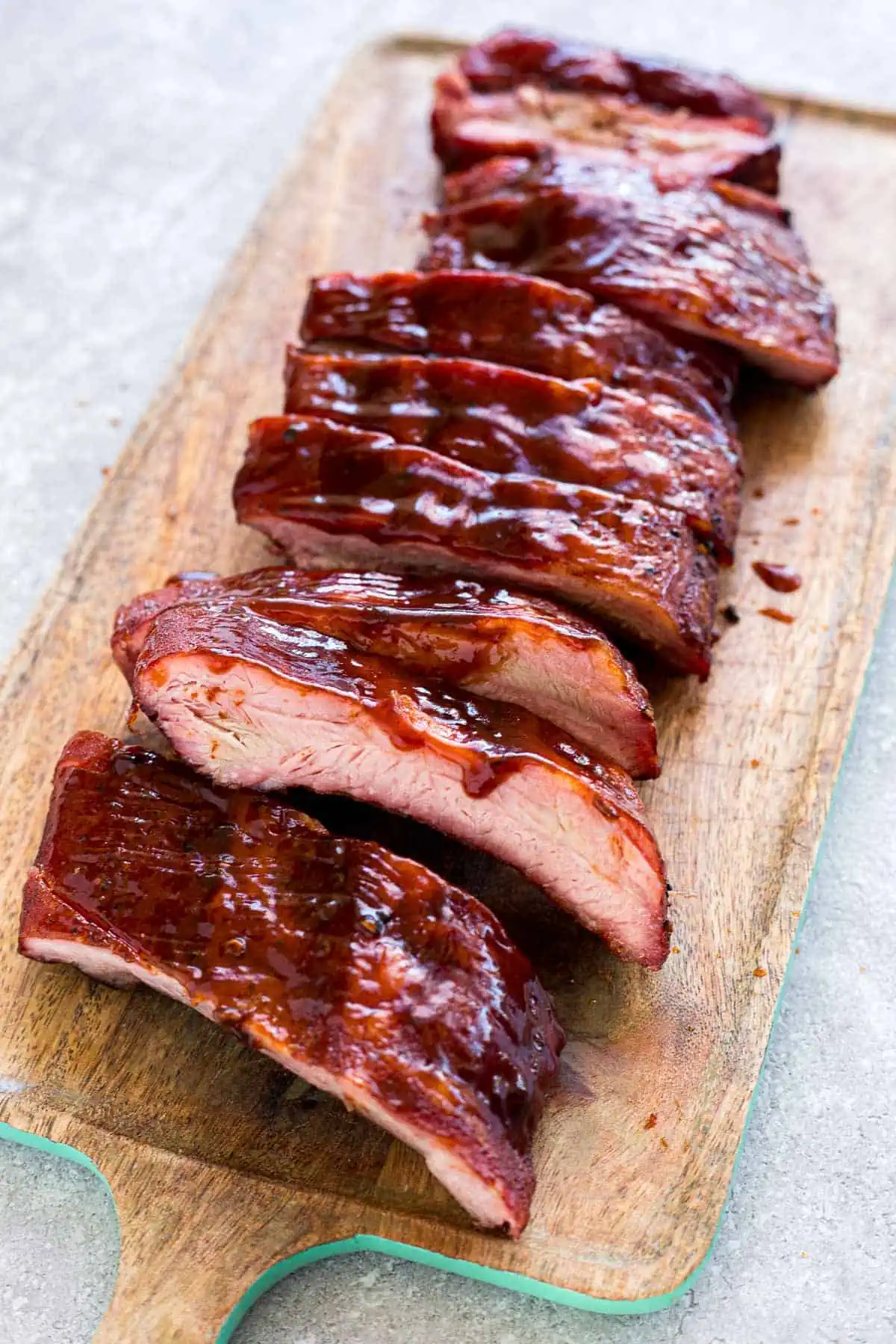 BBQ coated pork spare ribs on a cutting board