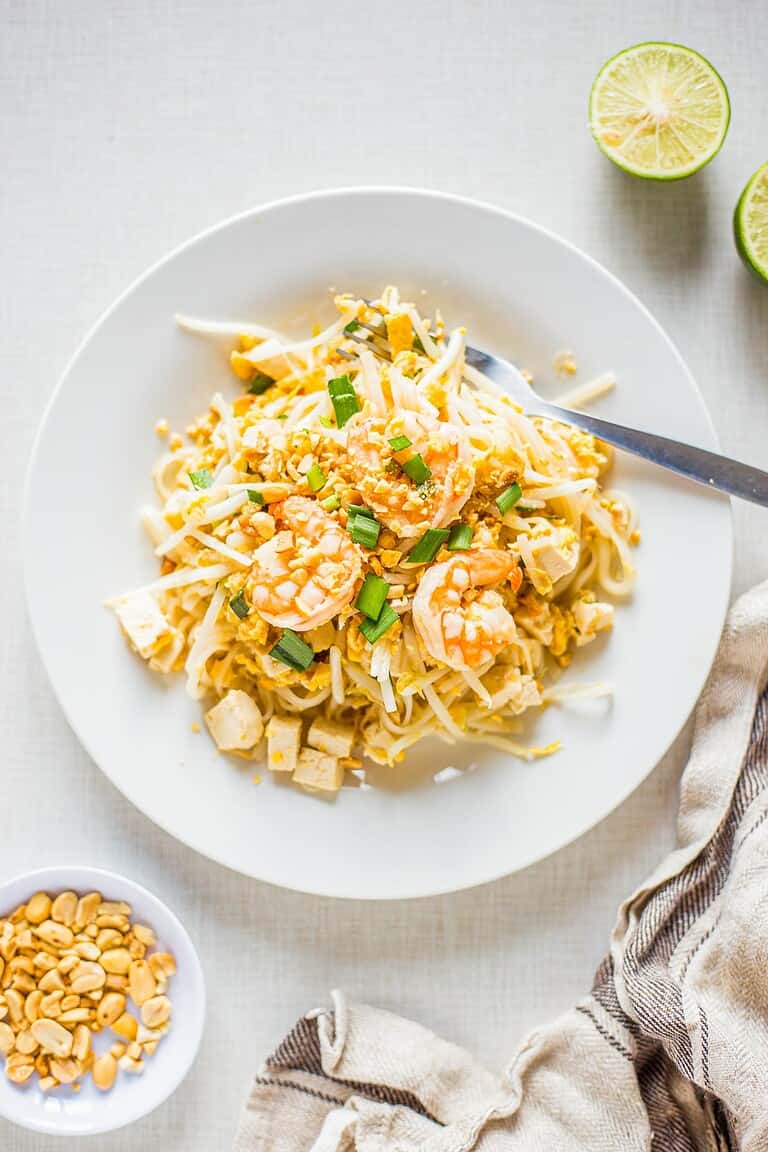 Shrimp Pad Thai on a white plate with garnishes
