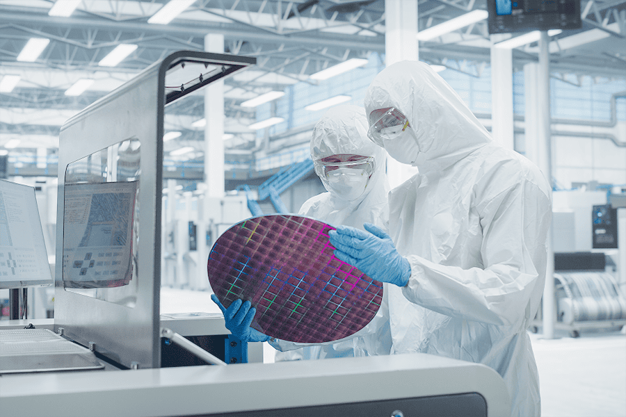 Technician in a cleanroom recording measurements on a clipboard during laboratory or environmental monitoring.