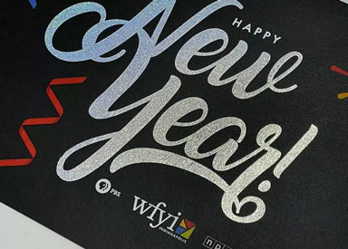 Greeting card featuring the text 'Happy New Year!' in holographic foil on a black background.
