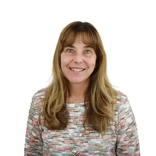 Headshot of a woman with long brown hair wearing a patterned sweater, smiling at the camera.