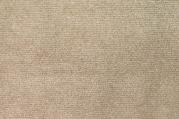 Close-up view of laid brownish recycled paper with a textured surface.