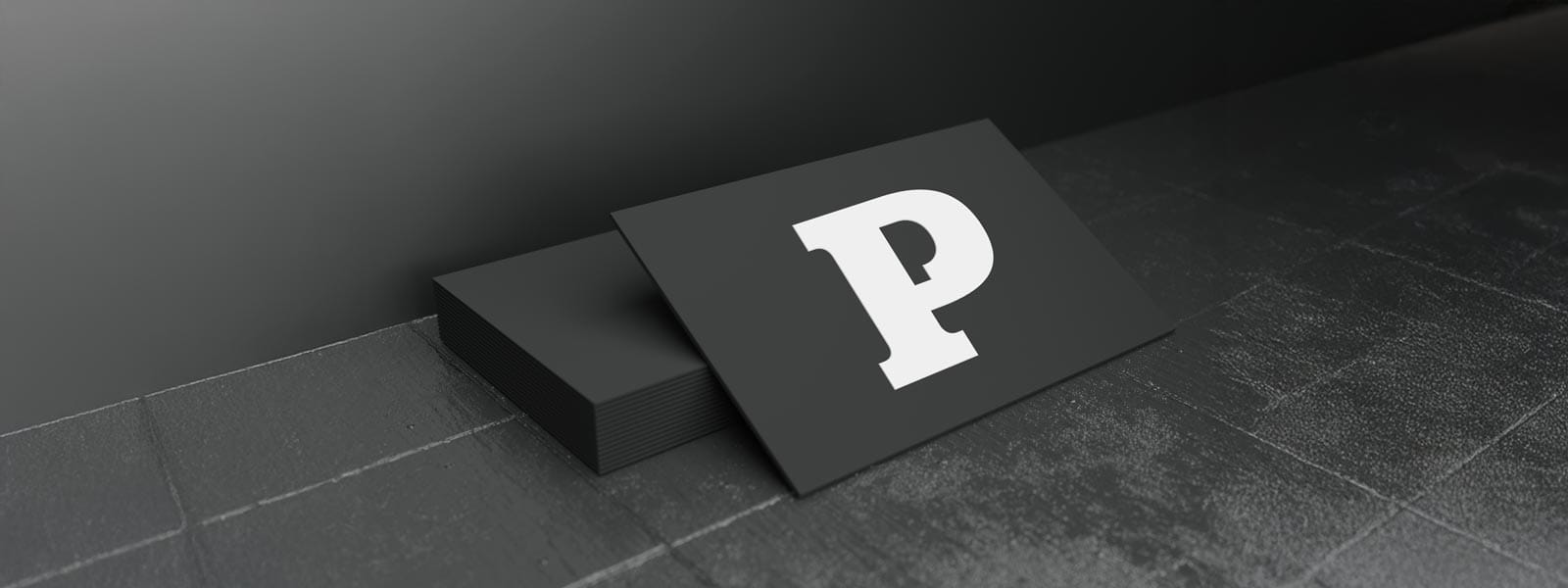 Black business card with a prominent white letter P displayed on a surface.