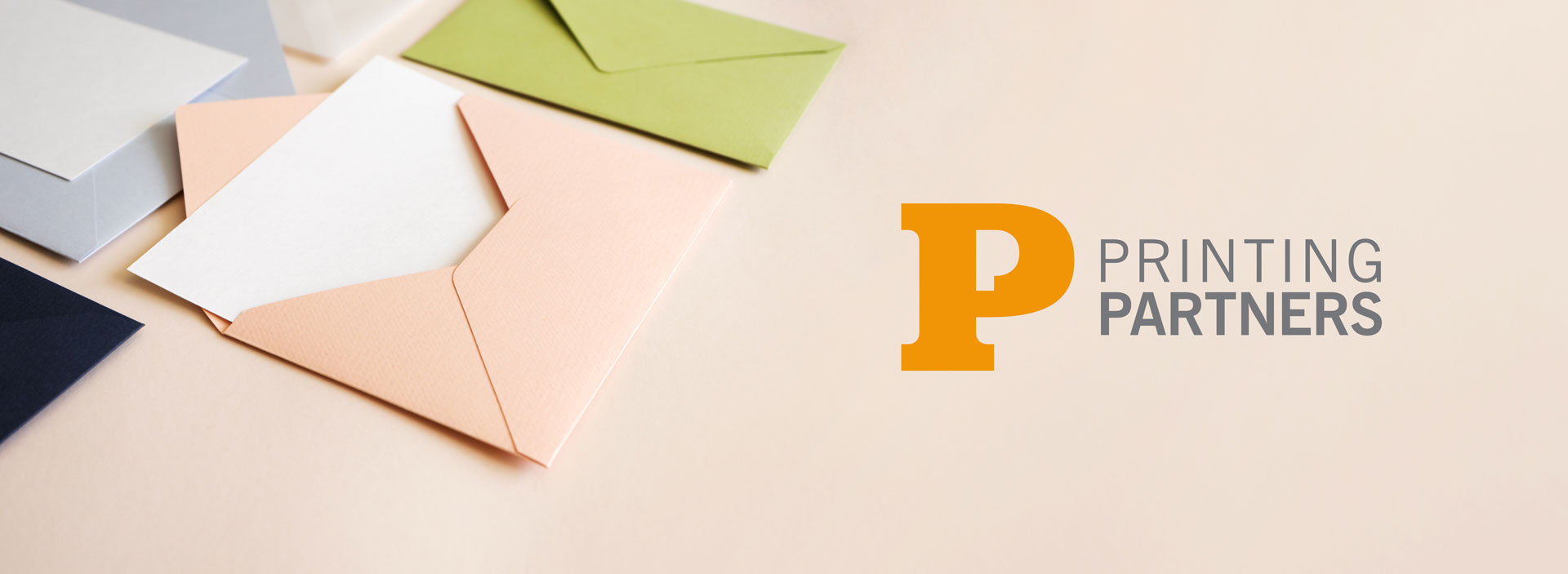 Various custom printed envelopes in different colors arranged on a surface.