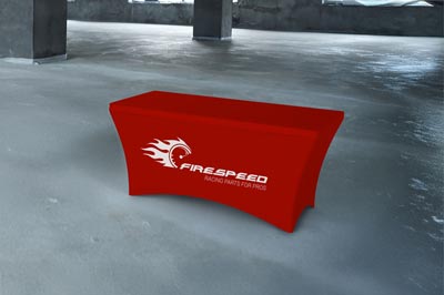 Red stretch table cloth with 'FIRESPEED' logo displayed on a table in an indoor setting.
