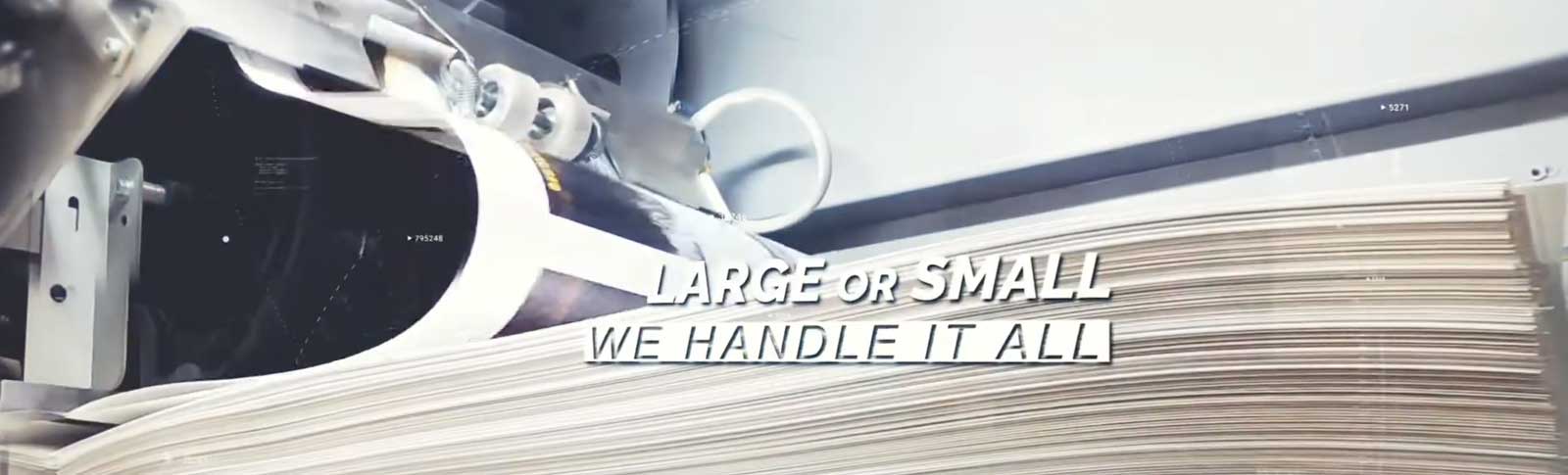 Close-up of a digital printing machine with large sheets of paper being processed.