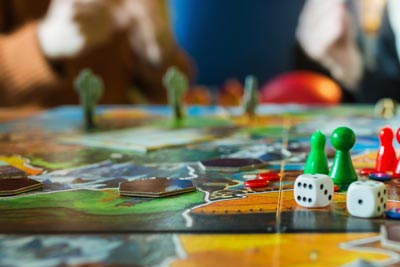 Close-up of a game board featuring colorful game pieces, dice, and tokens.