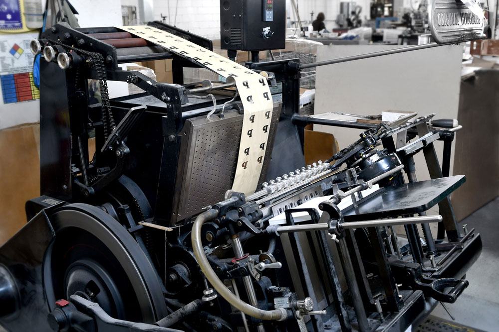 Heidelberg letterpress foil stamping machine with a roll of printed material.