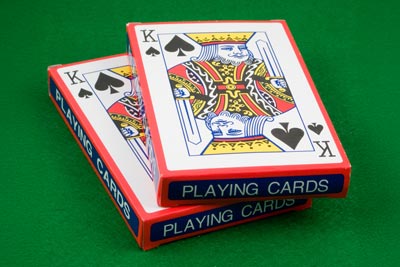 Two decks of playing cards stacked on top of each other with a King of Spades design on the top deck.