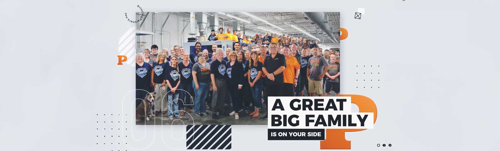 A large group of people posing together in a commercial setting, wearing matching shirts.