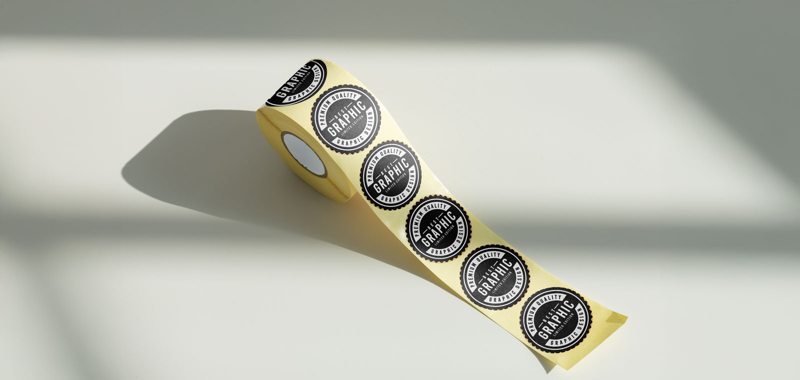 A roll of yellow stickers featuring black circular graphics with text on them.
