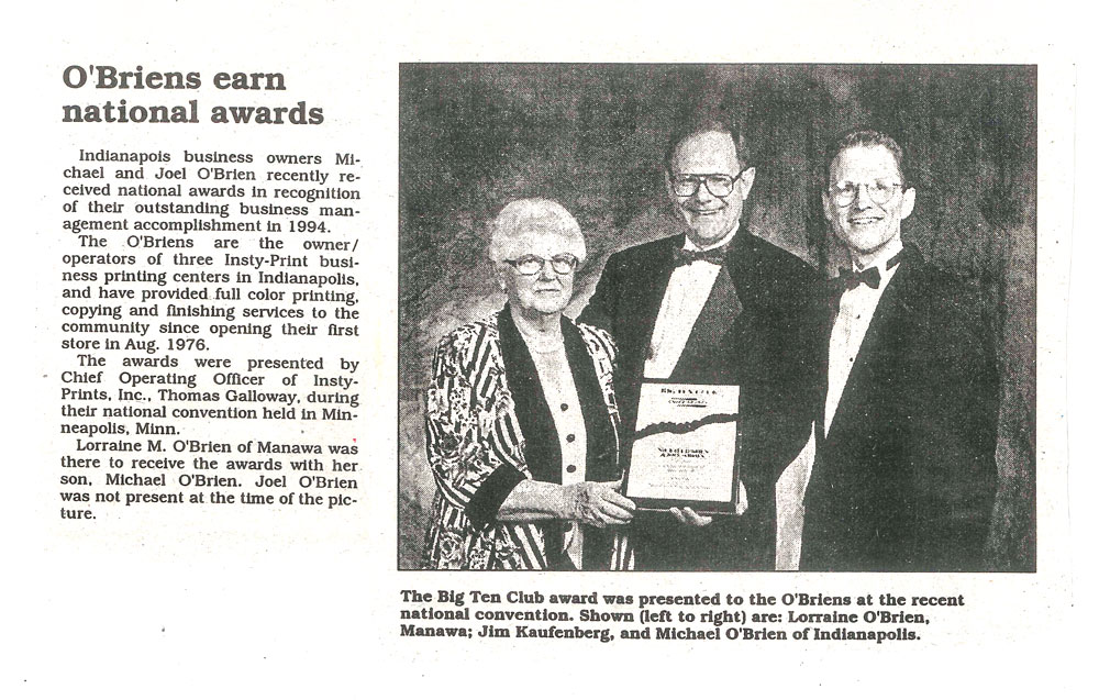 Black and white photo of Michael and Joel O'Brien with Lorraine O'Brien receiving an award.