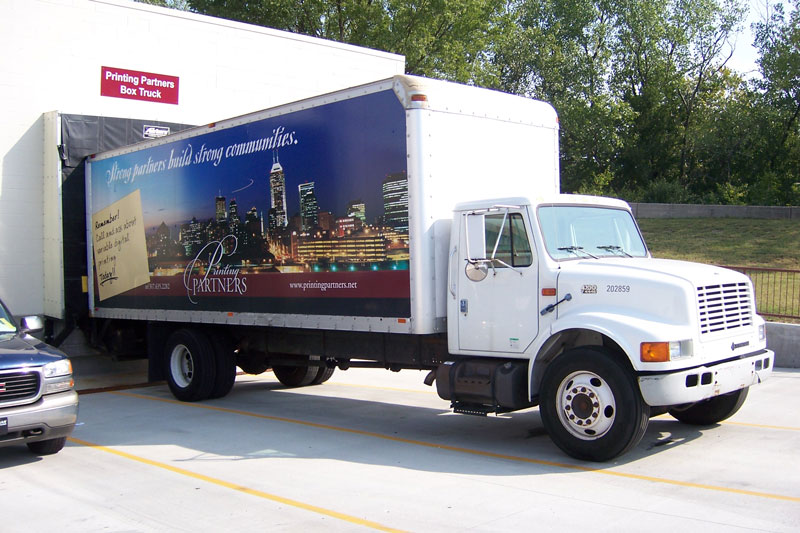 Box truck with Printing Partners branding parked in a lot.