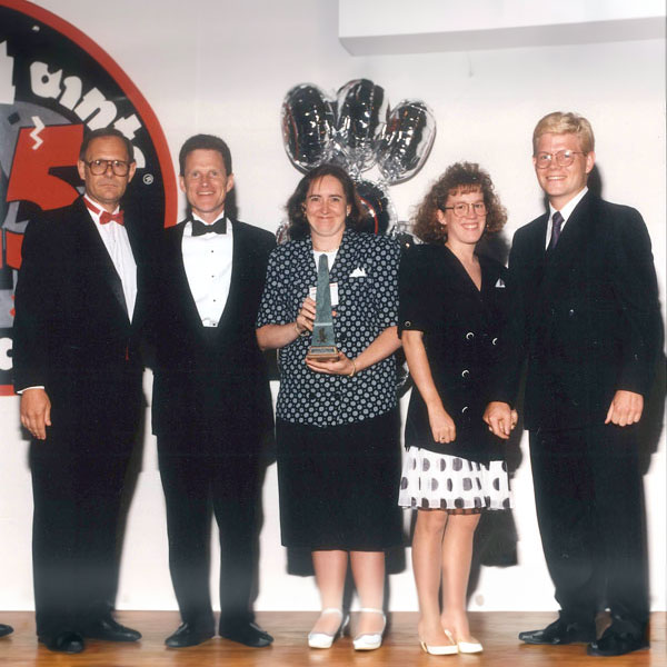 Group of individuals posing for a photo during an award presentation, including Robin Wilson, Charlie Sykes, and Jean Pritzker.