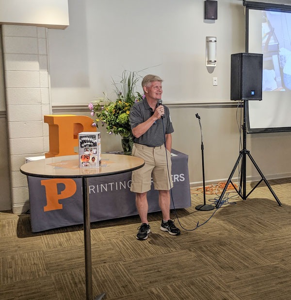 A man speaking at a podium during the Printing Partners 30 Year Anniversary event.