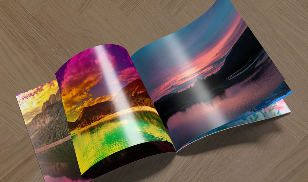 Open glossy brochure displaying vibrant landscape images with colorful skies and water reflections.