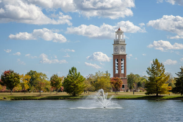 Bell tower with clock and fountain in a lake at Coxhall Gardens in Carmel, Indiana.
