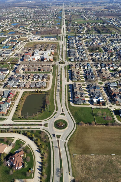 Aerial view of roundabouts and residential areas in Carmel, Indiana, showcasing road layout and housing developments.