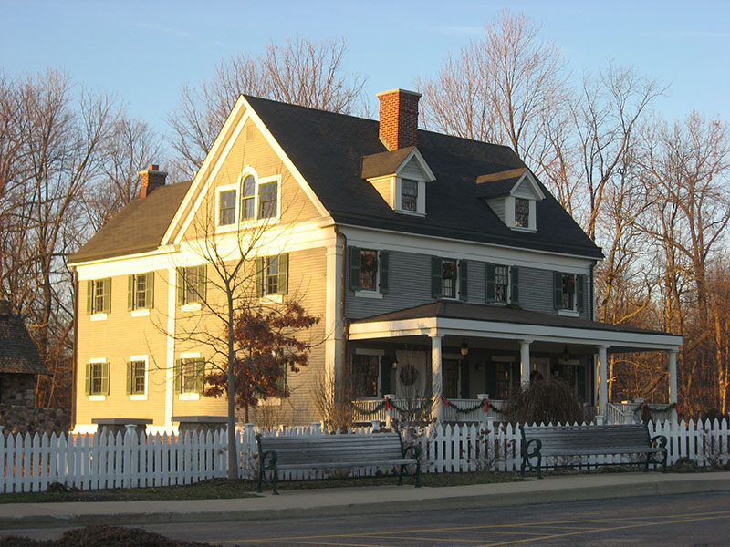 West Harris House, a large two-story home in Fishers, Indiana, with a white picket fence and seasonal decorations.