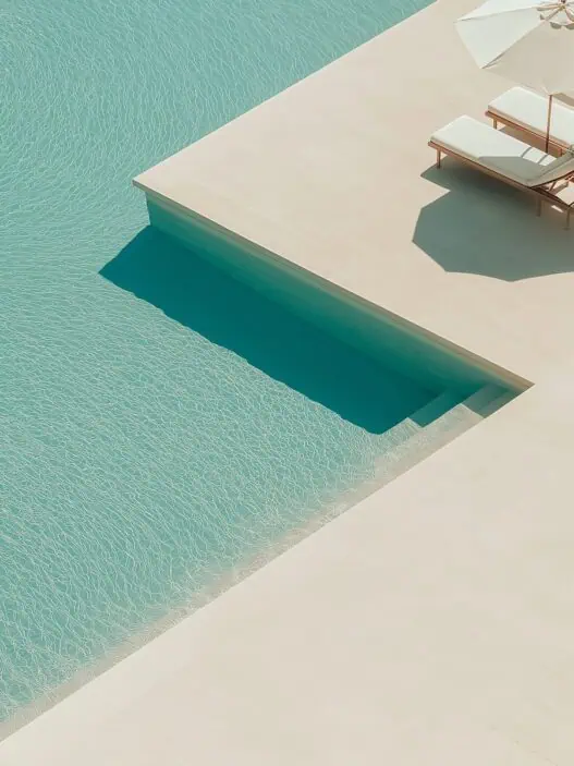 a pool with lounge chairs and a step