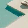 a pool with lounge chairs and a step