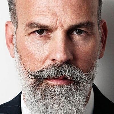 Experienced businessman with a grey beard and confident expression, representing professional expertise and financial leadership in the investment and hedge fund industry.