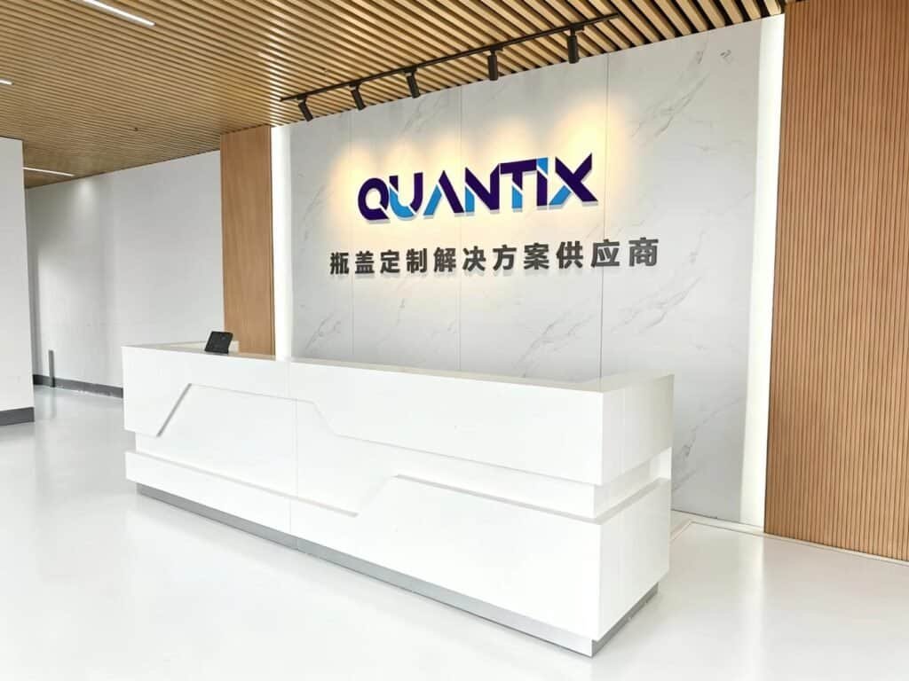 Modern office reception with Quantix logo and clean white desk, showcasing professional corporate environment.