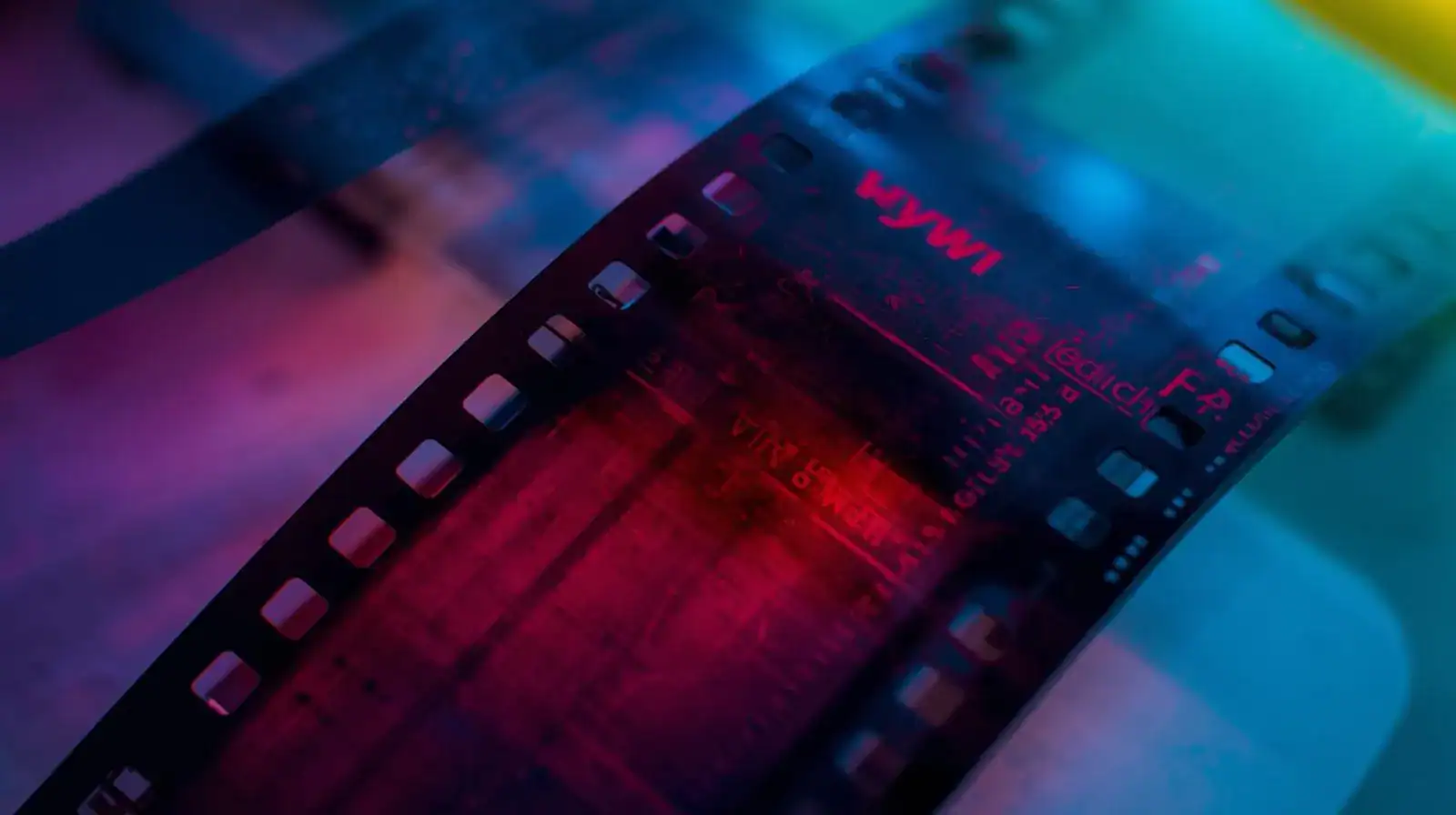 Rollo de película fotográfica en colores vibrantes, con luz neón y ambiente cinematográfico, ideal para cine lovers y amantes del séptimo arte.