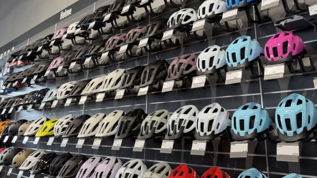 Bunte Fahrradhelme in verschiedenen Farben und Designs im Fachgeschäft.