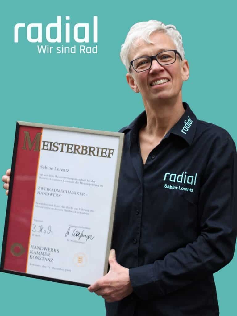 Radial-Mitarbeiterin mit Meisterbrief in Hand, stolz und professionell.