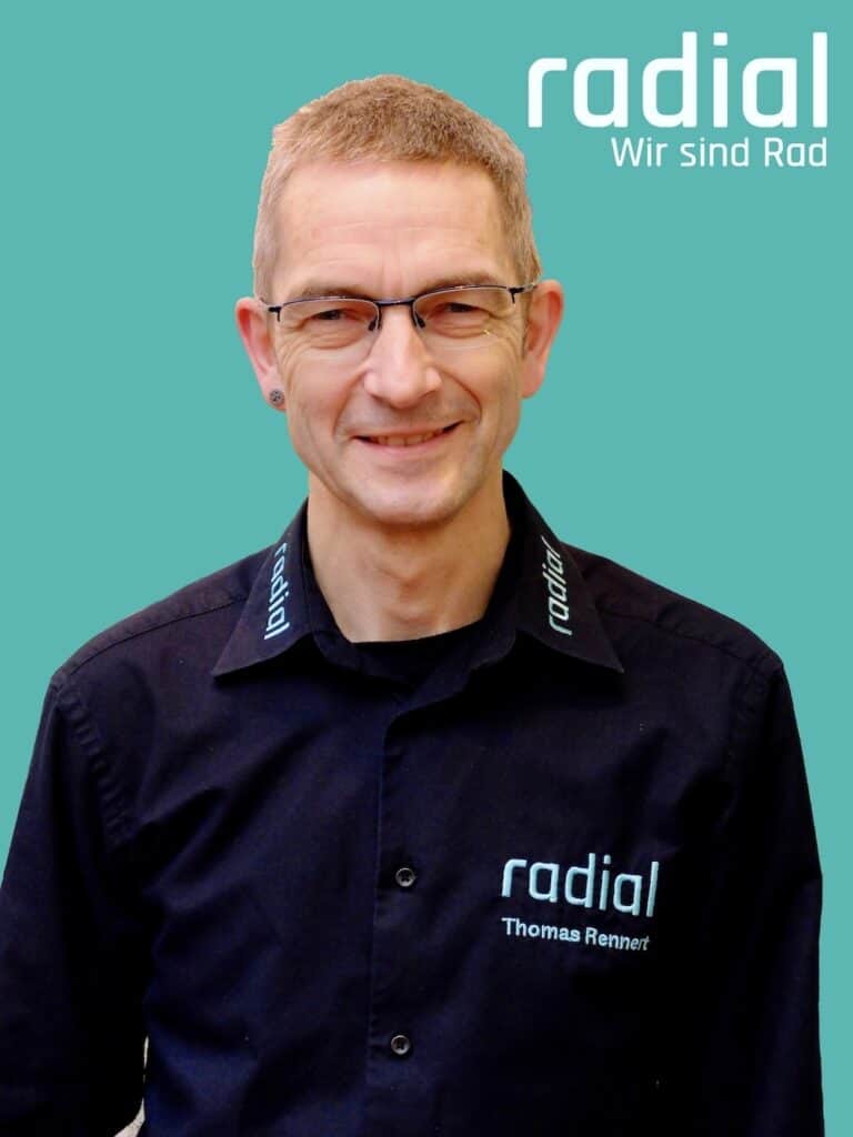 Mann in Radial Firmenkleidung vor grünem Hintergrund.