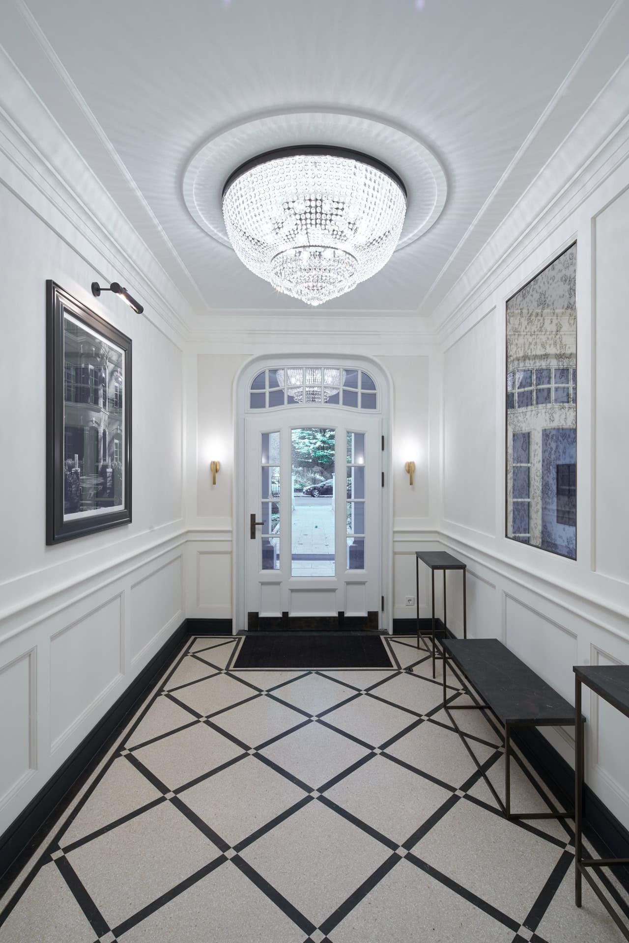 Elegante Eingangshalle in Hamburg mit Kronleuchter, Fenstern und Akzenten.
