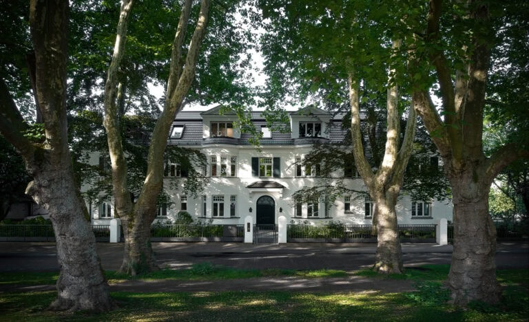 Frontfassade der Brohler Strasse mit Plantanen mit freiem Blick auf das Eingangsportal