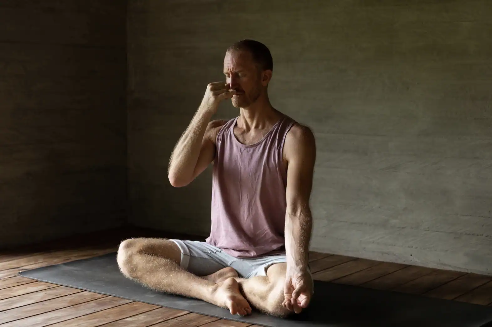 Man doing breathwork meditation indoors on a mat