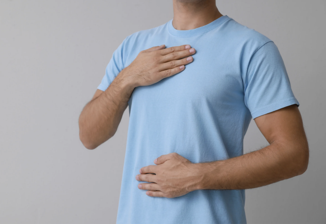 Man with one hand on his chest and one hand on his belly.