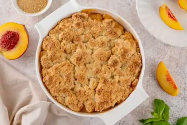 crumble aux pêches doré dans un plat à gratin