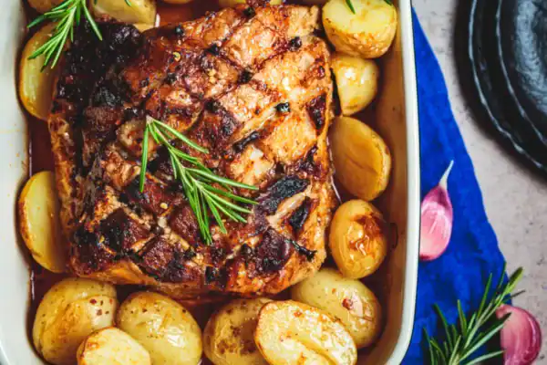 palette de porc au four dorée avec pommes de terre fondantes dans son plat