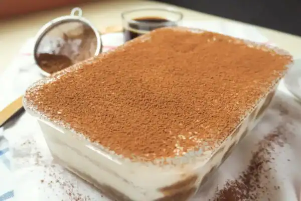tiramisu au Thermomix dans un plat rectangulaire saupoudré de cacao