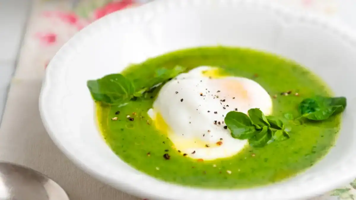 Velouté de cresson au Thermomix vert vif servi avec un filet de crème