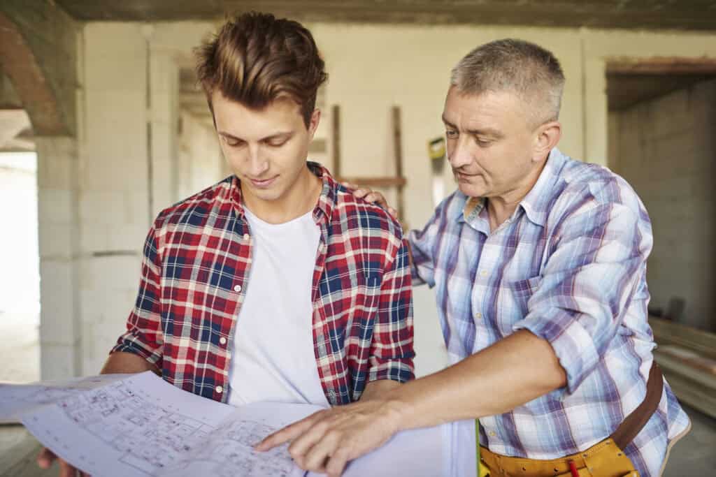 High-quality home renovation consultation with expert contractor discussing blueprints indoors.