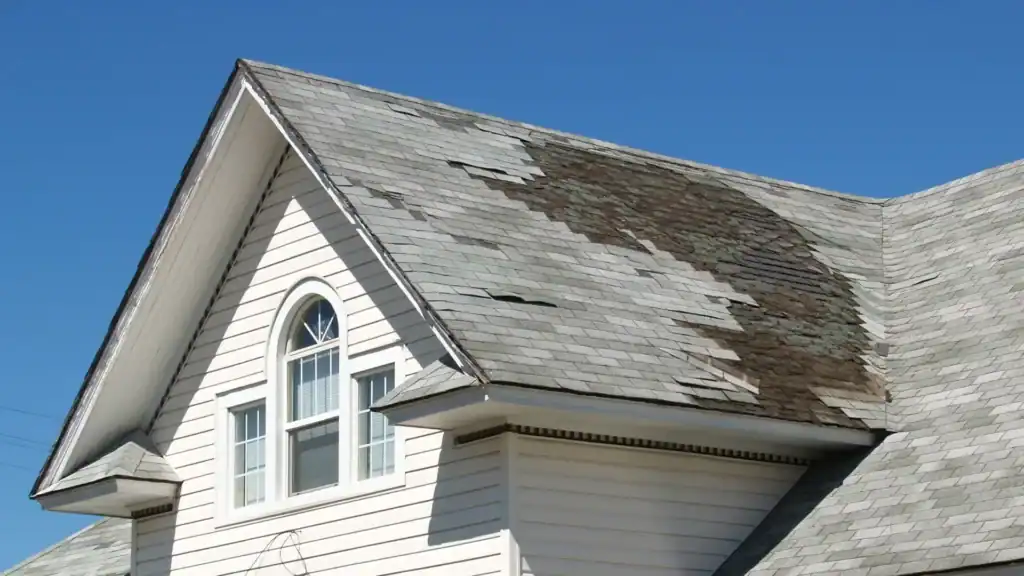 Storm-damaged roof with missing shingles after heavy rainfall
