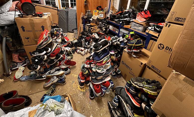 Cluttered storage room filled with organised piles of running shoes and sports gear, suitable for runners and athletes.